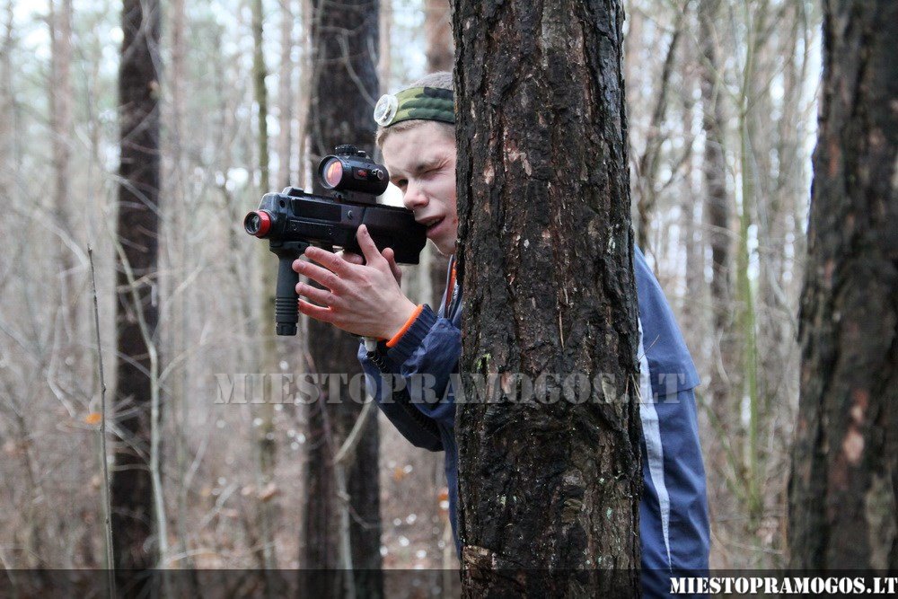 Berniukas miške pozuoja su Laser Tag įranga